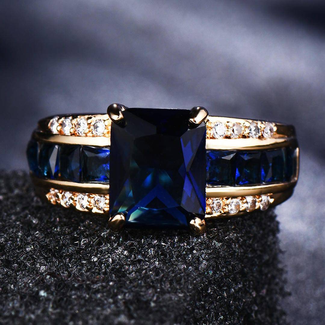 Bague en velours saphir Danoir Paris avec pétales en or rose, élégante et fine, vue de face sur un fond neutre.