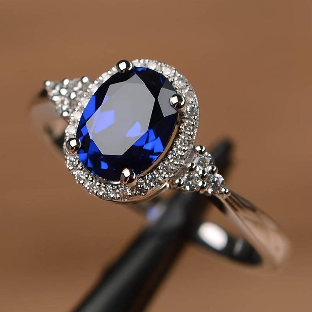 Bague Danoir Paris Midnight Majesty en or blanc avec saphir ovale bleu foncé, élégante et raffinée.
