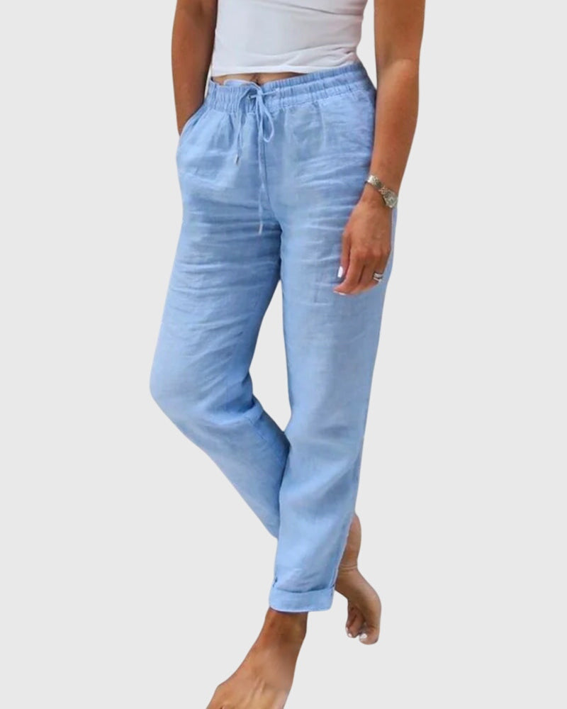 Pantalons élégants pour femmes Margaret™ de Danoir Paris, coupe ajustée et tissu fluide, portés avec une blouse blanche.