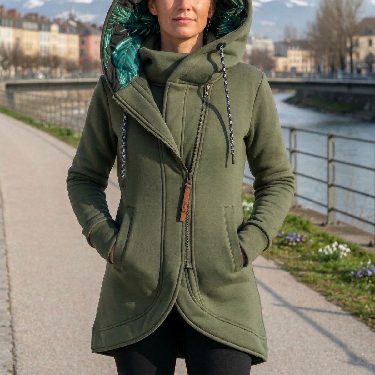 Veste de transition chaude Ann de Danoir Paris, en tissu épais, couleur gris clair, avec capuche et fermeture zippée.