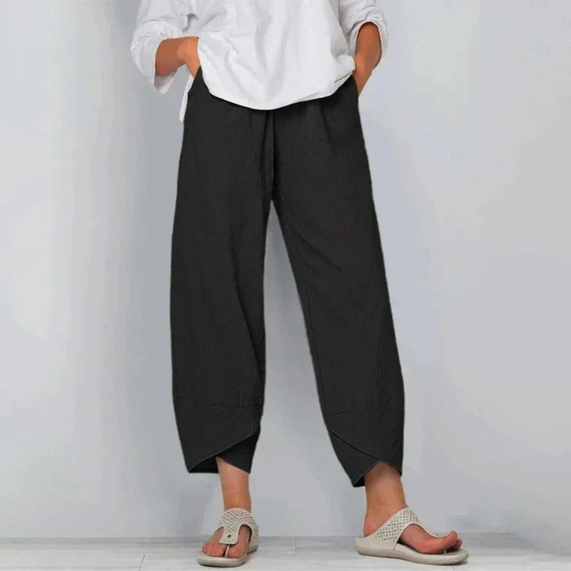 Pantalon d'été chic Garance de Danoir Paris, en tissu léger, coupe élégante, couleur neutre, porté avec une blouse blanche.