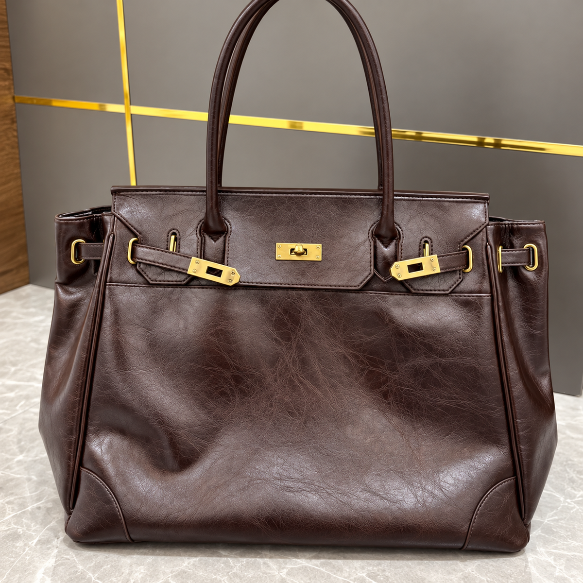 Sac à main Danoir Paris en cuir marron, sac cabas élégant posé sur une surface en marbre, fait main, retour en stock.