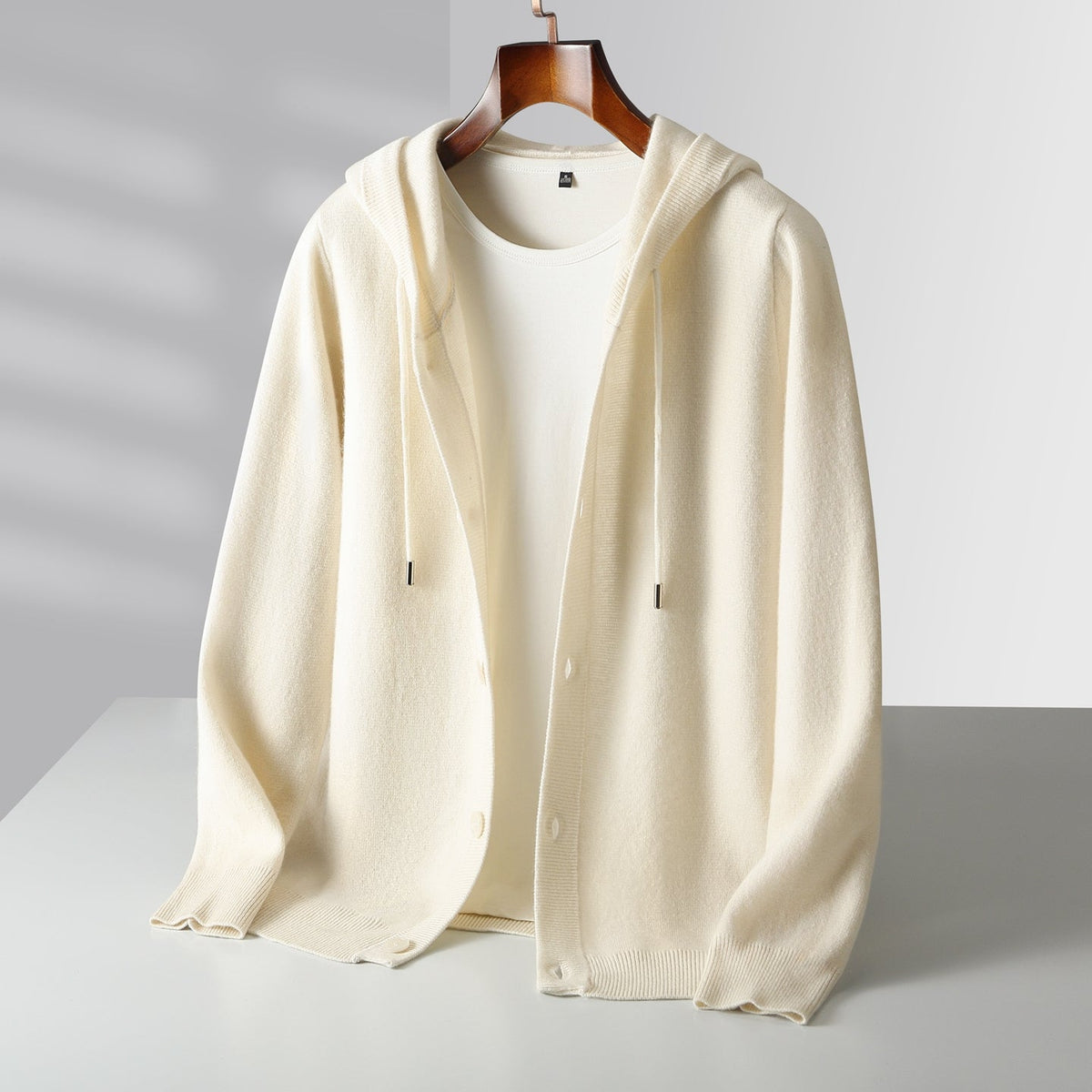 Cardigan à capuche en laine Danoir Paris avec boutons, vue de face, montrant la texture douce et le design élégant.