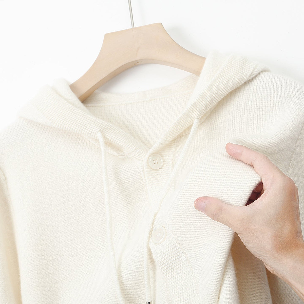 Cardigan à capuche en laine Danoir Paris avec boutons, montre la texture douce et la capuche attachée.