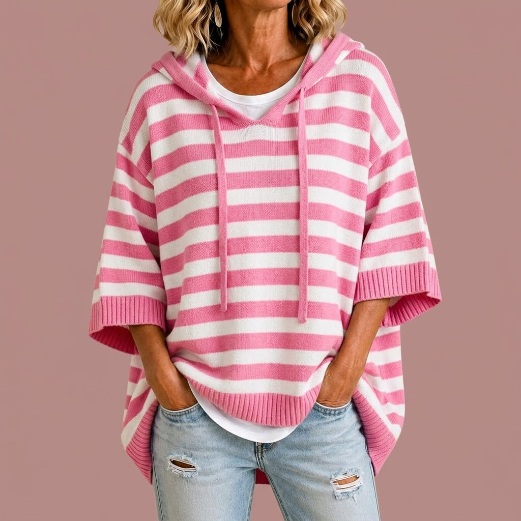 Poncho en maille rayée Danoir Paris avec capuche, douceur et style, porté en situation décontractée.