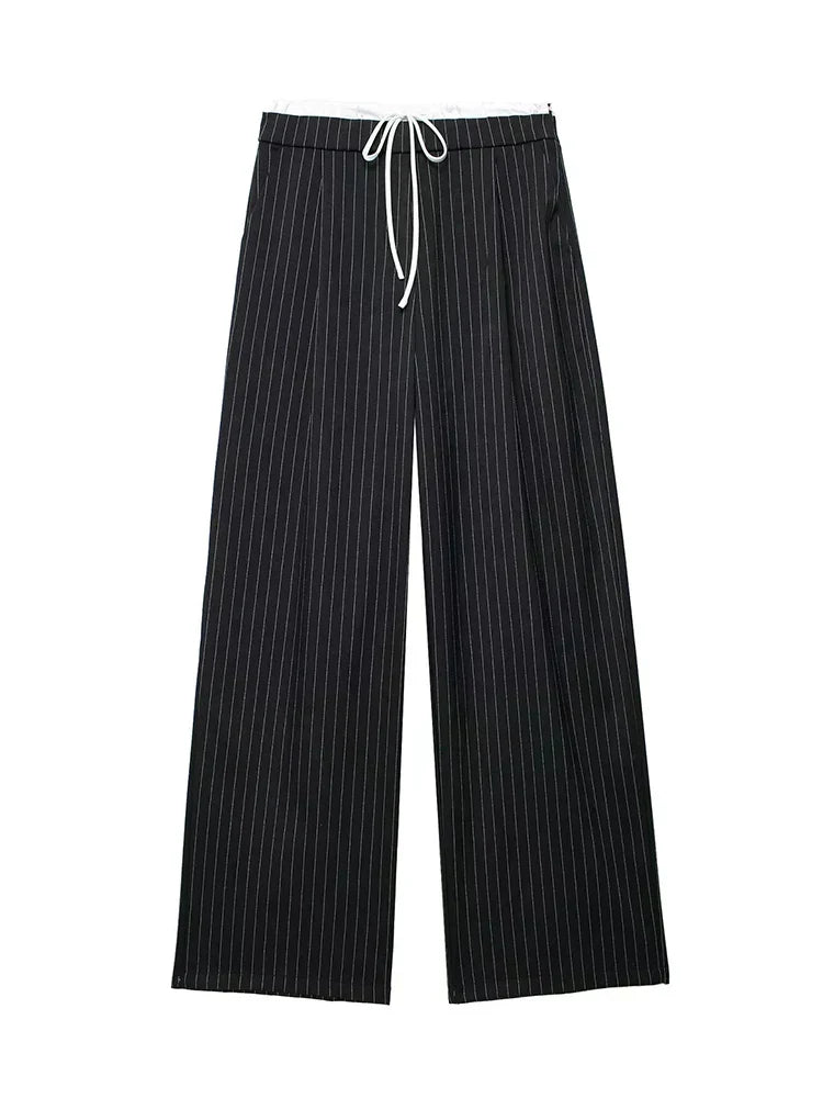 Pantalon Manon Danoir Paris en tissu léger, coupe ajustée, couleur beige, porté avec chemise blanche.