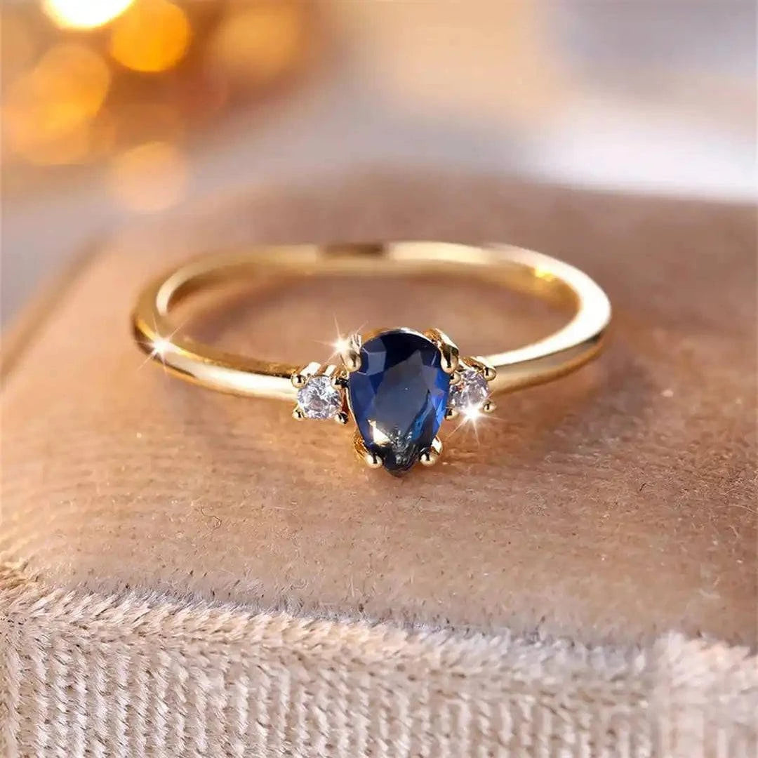 Bague minimaliste en or avec saphir royal en forme de poire, design élégant de Danoir Paris.