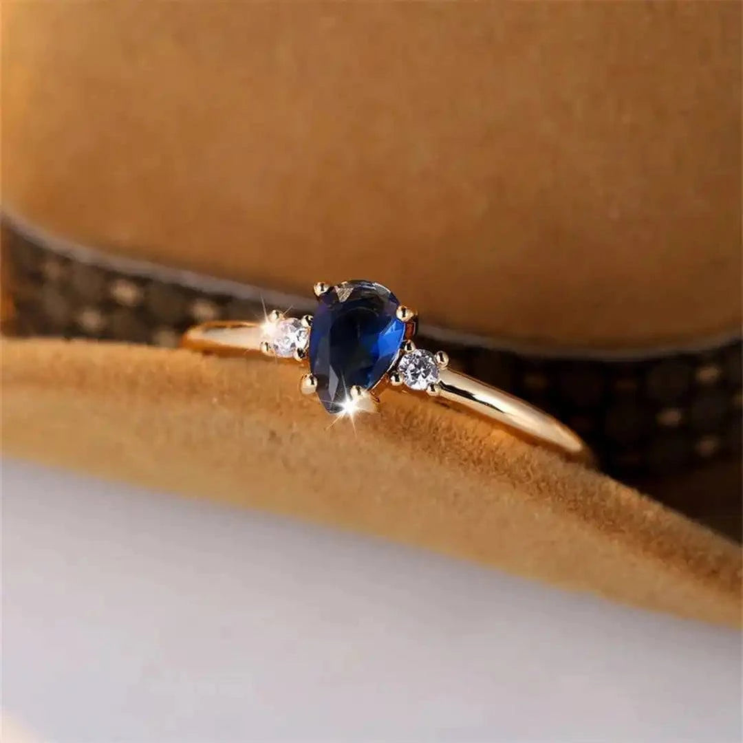 Bague minimaliste en or blanc avec saphir royal en forme de poire, design élégant, marque Danoir Paris.