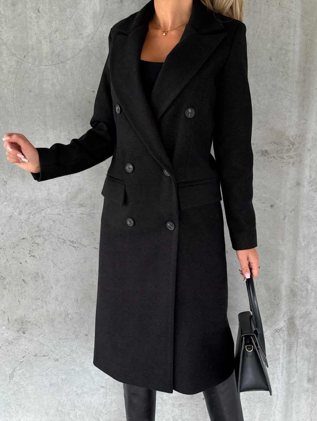Manteau intemporel Jolie de Danoir Paris avec coupe élégante et détails classiques, porté en extérieur.