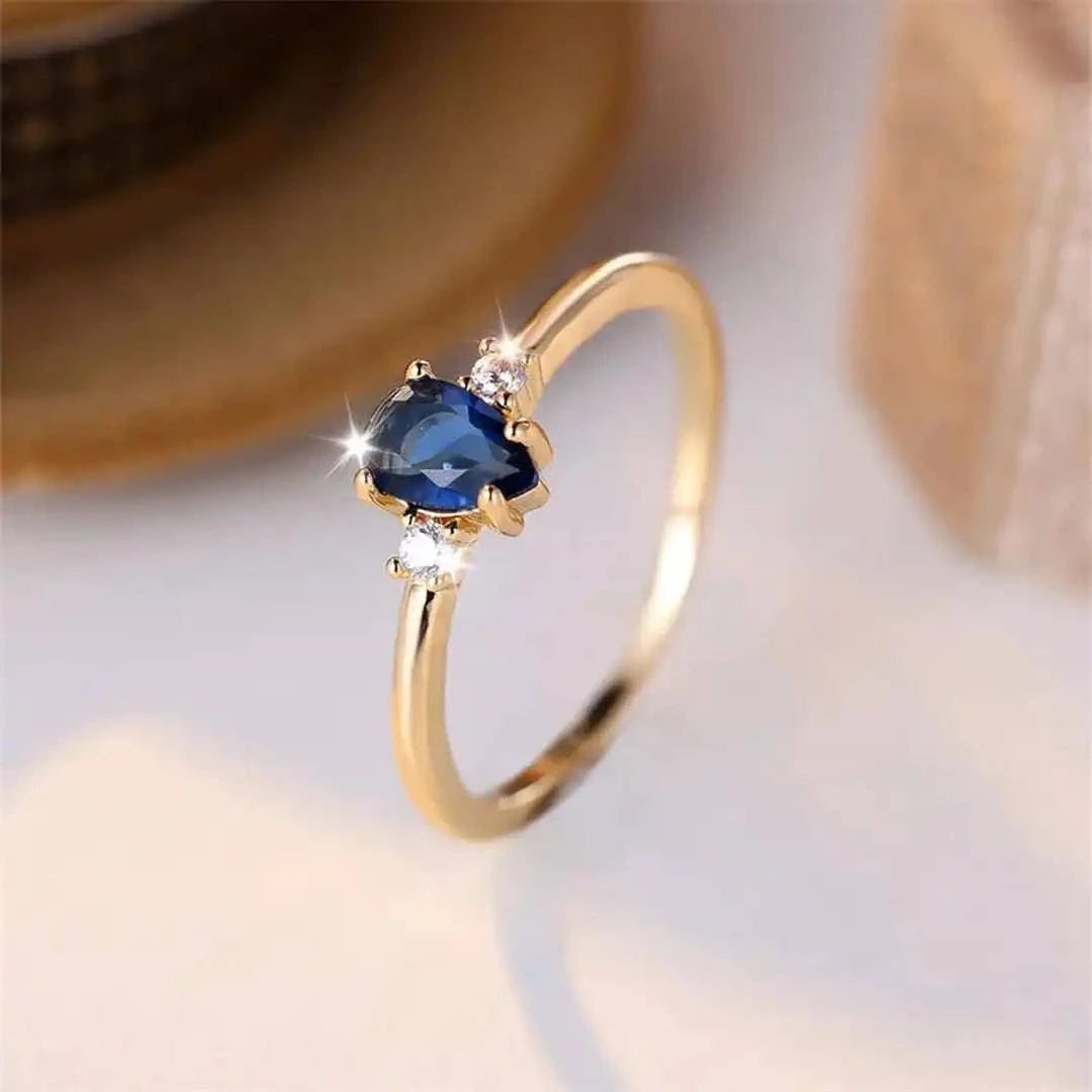 Bague minimaliste en or avec saphir royal en forme de poire, modèle Danoir Paris, vue de face.