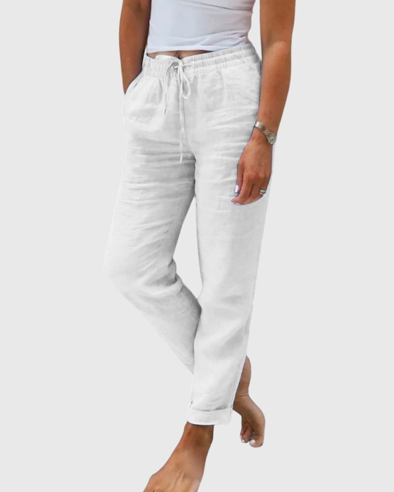 Pantalons élégants pour femmes Margaret™ de Danoir Paris, en tissu fluide avec coupe ajustée, portés avec une blouse blanche.