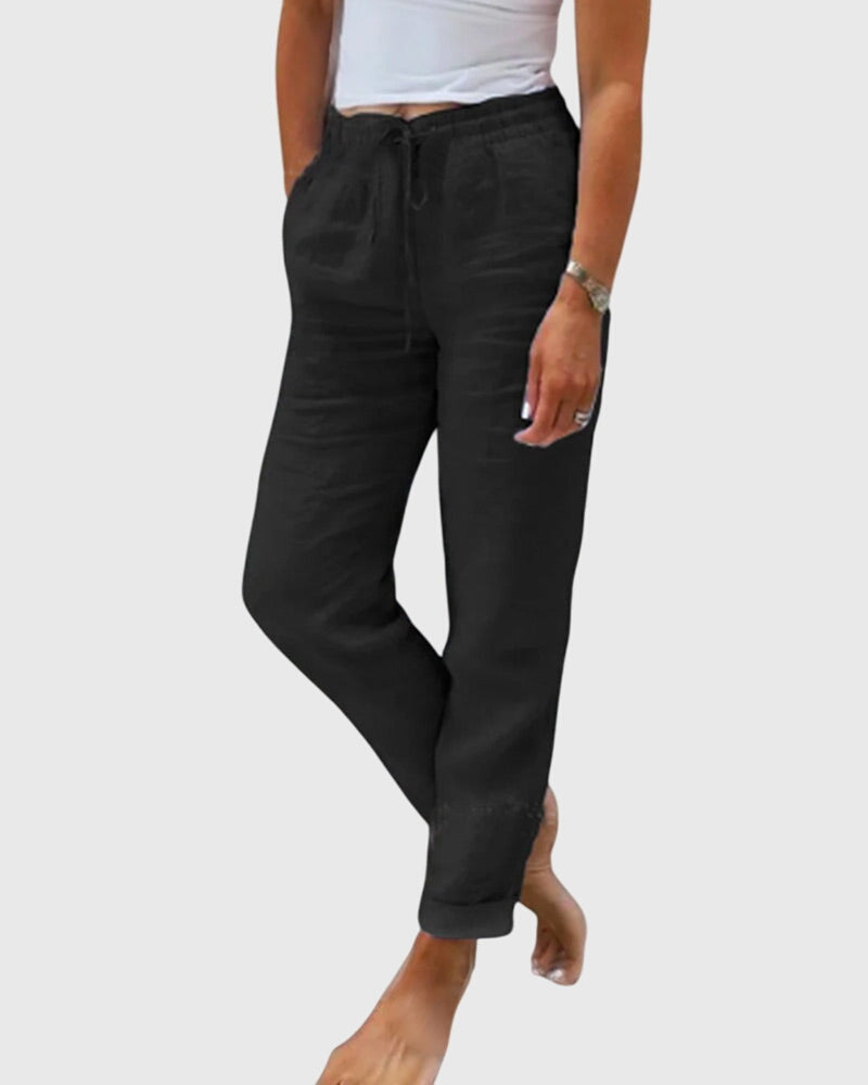 Pantalons élégants pour femmes Margaret™ de Danoir Paris, coupe fluide et tissu sophistiqué, portés avec une blouse blanche.