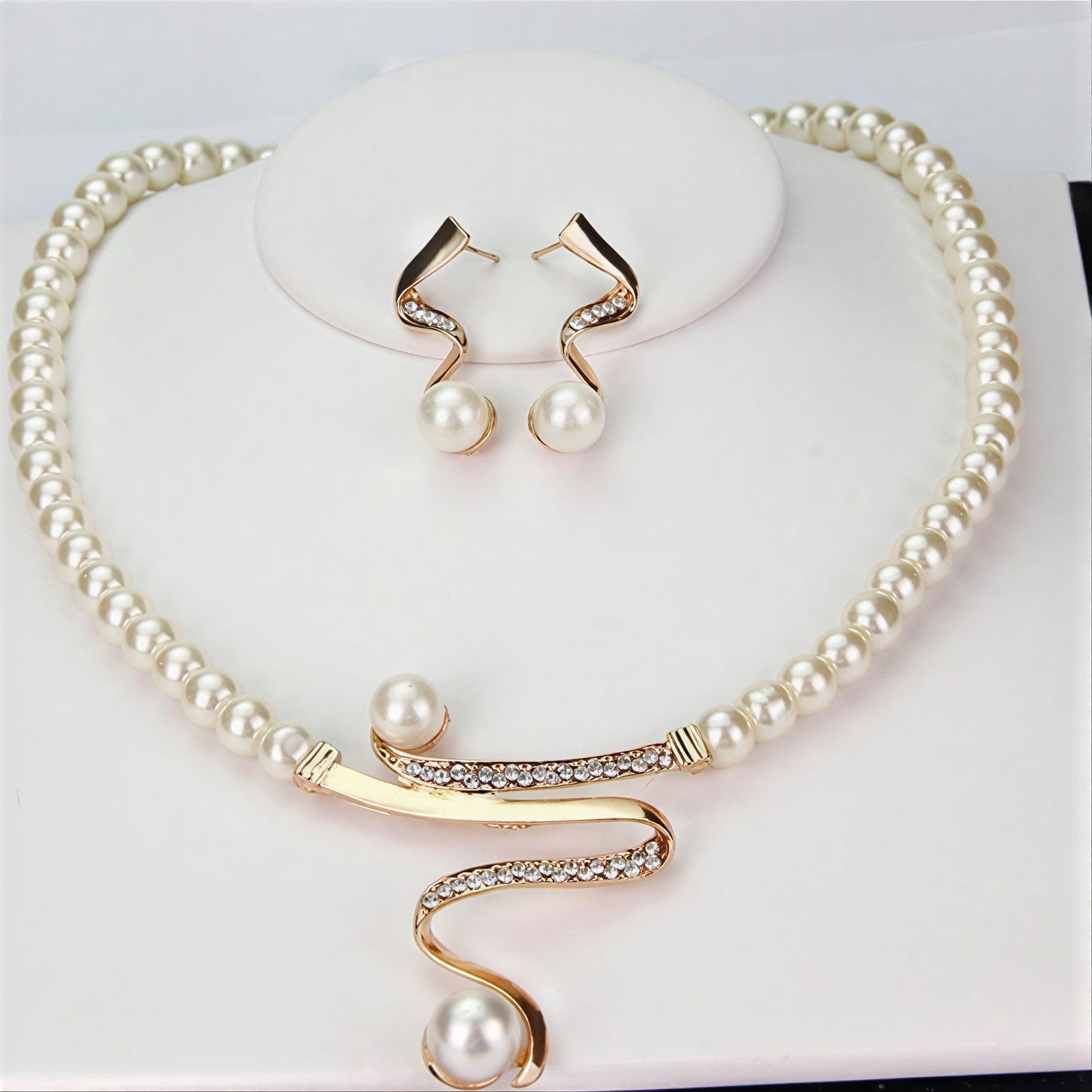 Ensemble de bijoux élégants avec perles en forme d'onde par Danoir Paris, comprenant boucles d'oreilles et collier sophistiqués.