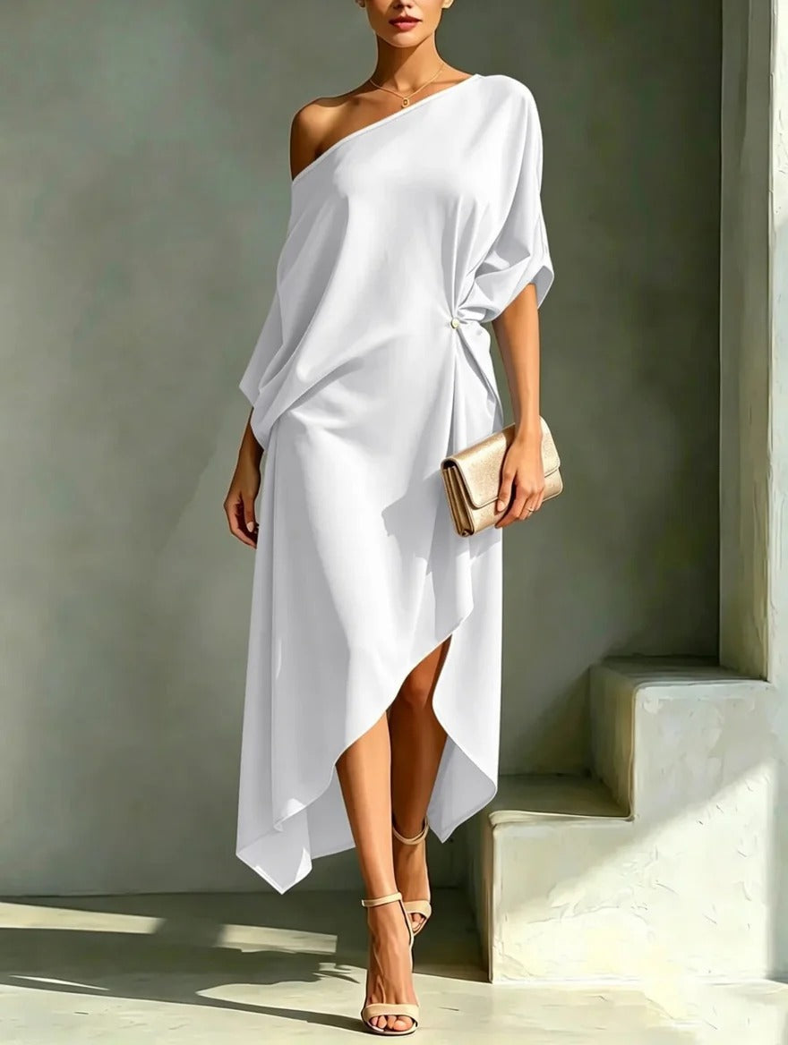 Robe asymétrique élégante Camila blanche de Danoir Paris, tissu fluide, design moderne et sophistiqué, porté avec accessoires.