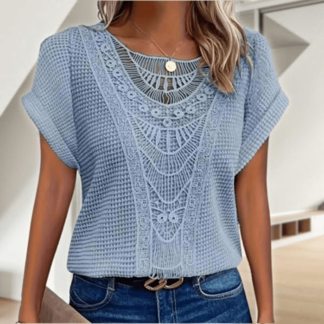 Blouse élégante en dentelle Karin de Danoir Paris, détail de la dentelle fine et coupe féminine visible sur l'image.
