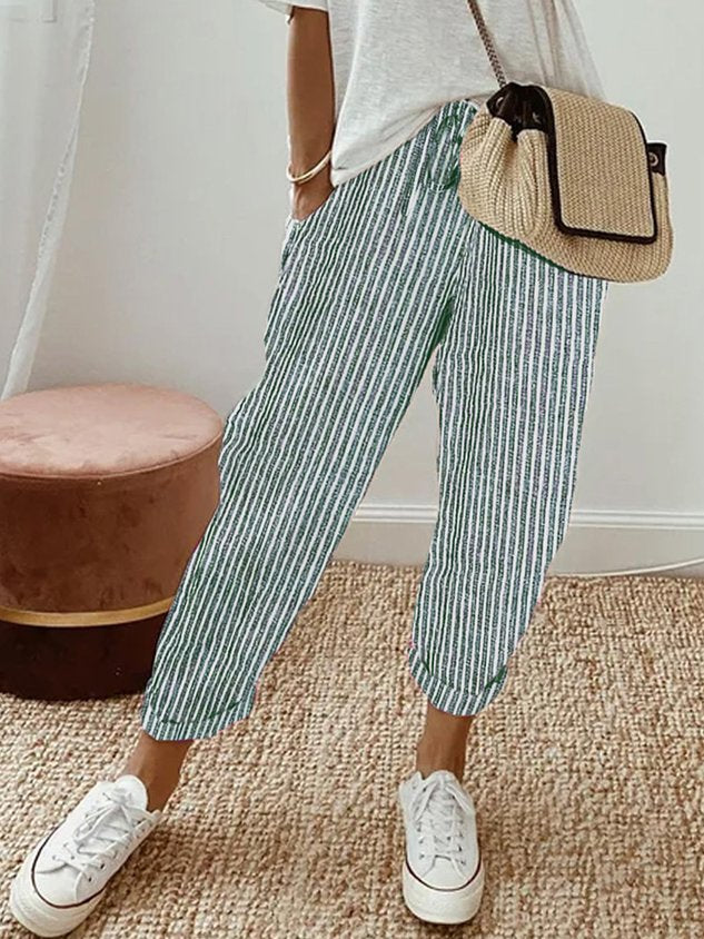 Pantalons fluides Danoir Paris, confortables et élégants, en tissu léger avec coupe moderne, portés avec une blouse blanche.