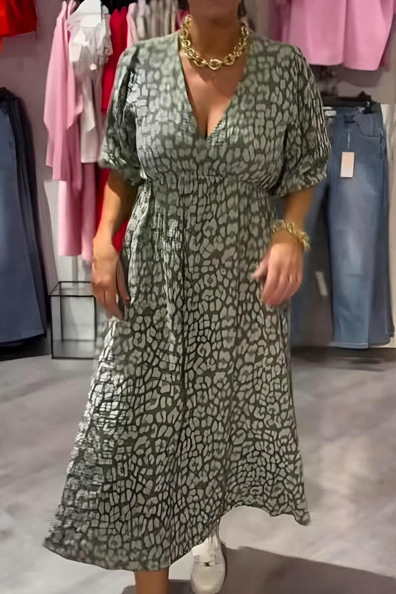 Robe d'été élégante Claudia de Danoir Paris, tissu léger avec motifs floraux, portée avec manches courtes et coupe fluide.