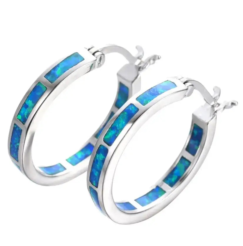 Boucles d'oreilles en cerceau chic avec opale de feu bleue, bijoux élégants de Danoir Paris, ornées de pierre précieuse bleue.