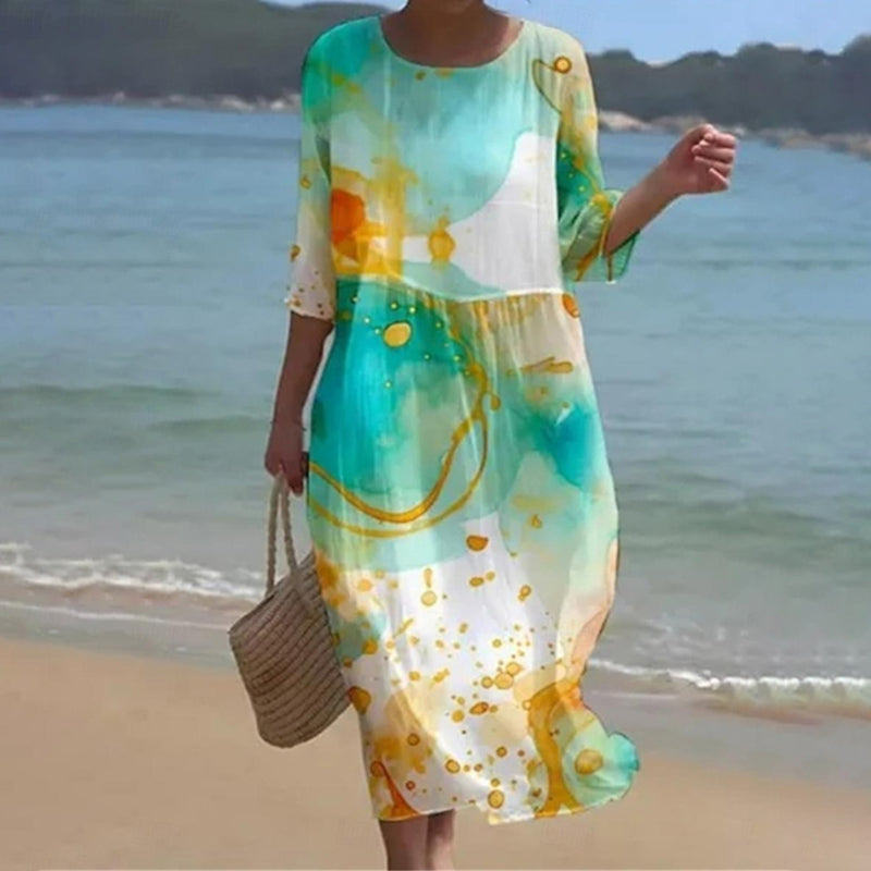 Robe florale chic Miranda de Danoir Paris, en tissu bleu avec motif floral élégant, portée avec manches longues et coupe raffinée.