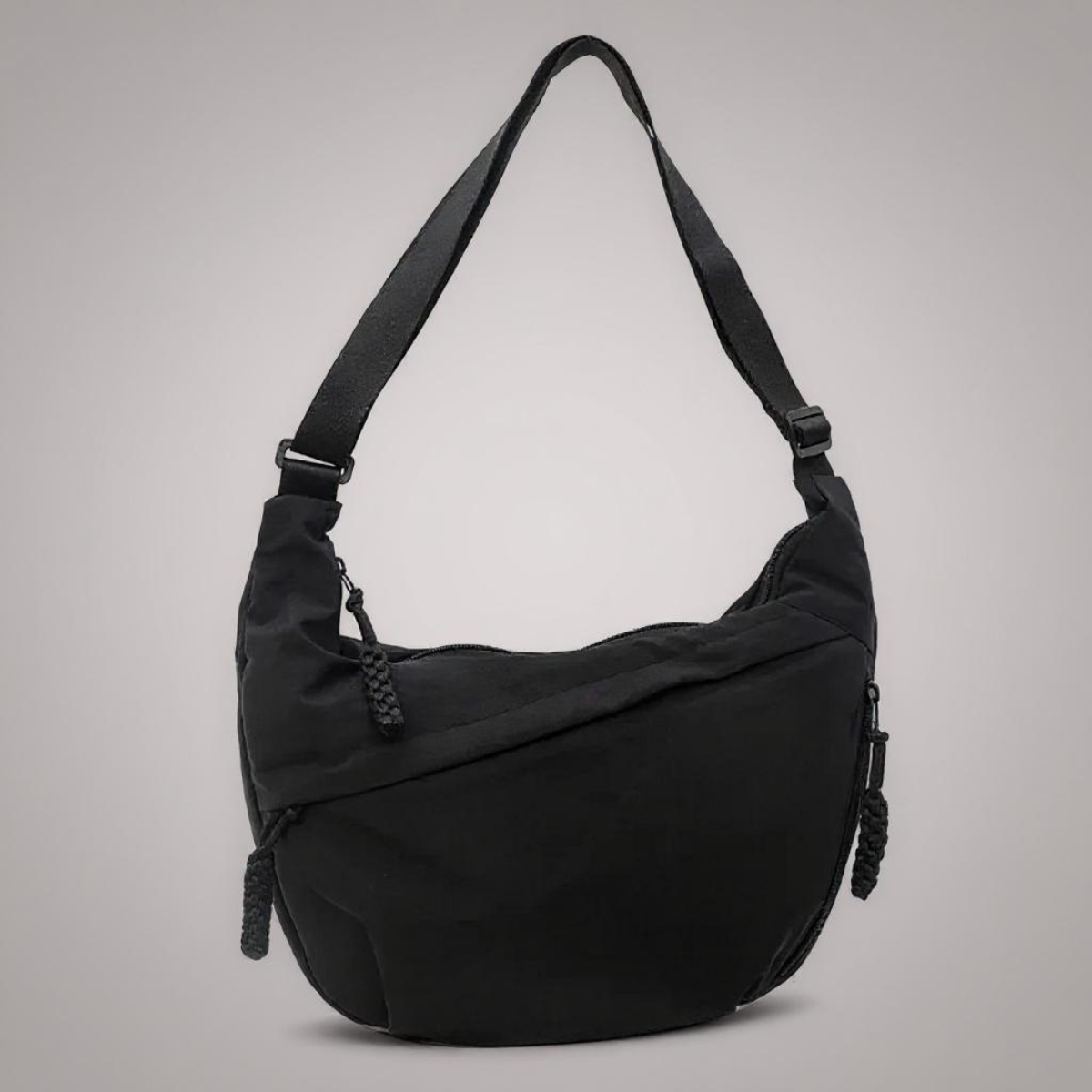 Sac à bandoulière noir Aria de Danoir Paris avec détails en cuir et poignées élégantes, vue de côté.