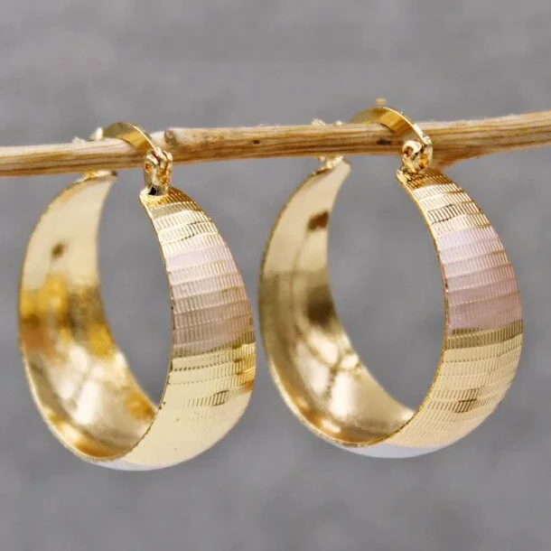 Boucles d'oreilles en or de luxe raffiné de la marque Danoir Paris, détails élégants visibles.