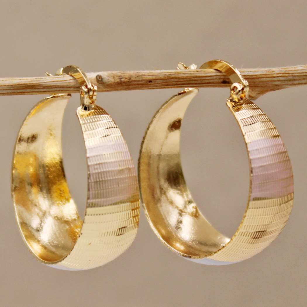 Boucles d'oreilles en or de luxe Danoir Paris, design raffiné et élégant, visibles avec détails métalliques brillants.