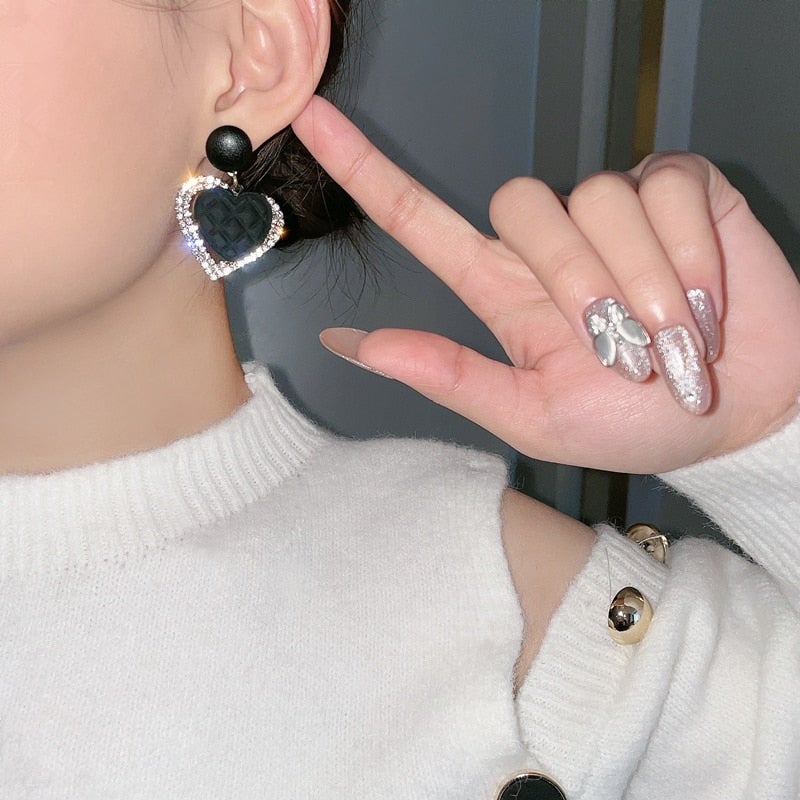 Boucles d'oreilles en or noir en forme de cœur de la marque Danoir Paris, montrant leur design élégant et brillant.