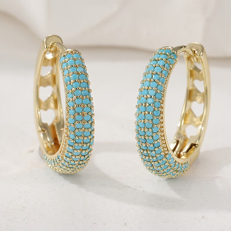Boucles d'oreilles turquoise charmantes de la marque Danoir Paris, en métal doré avec pierres turquoise brillantes.