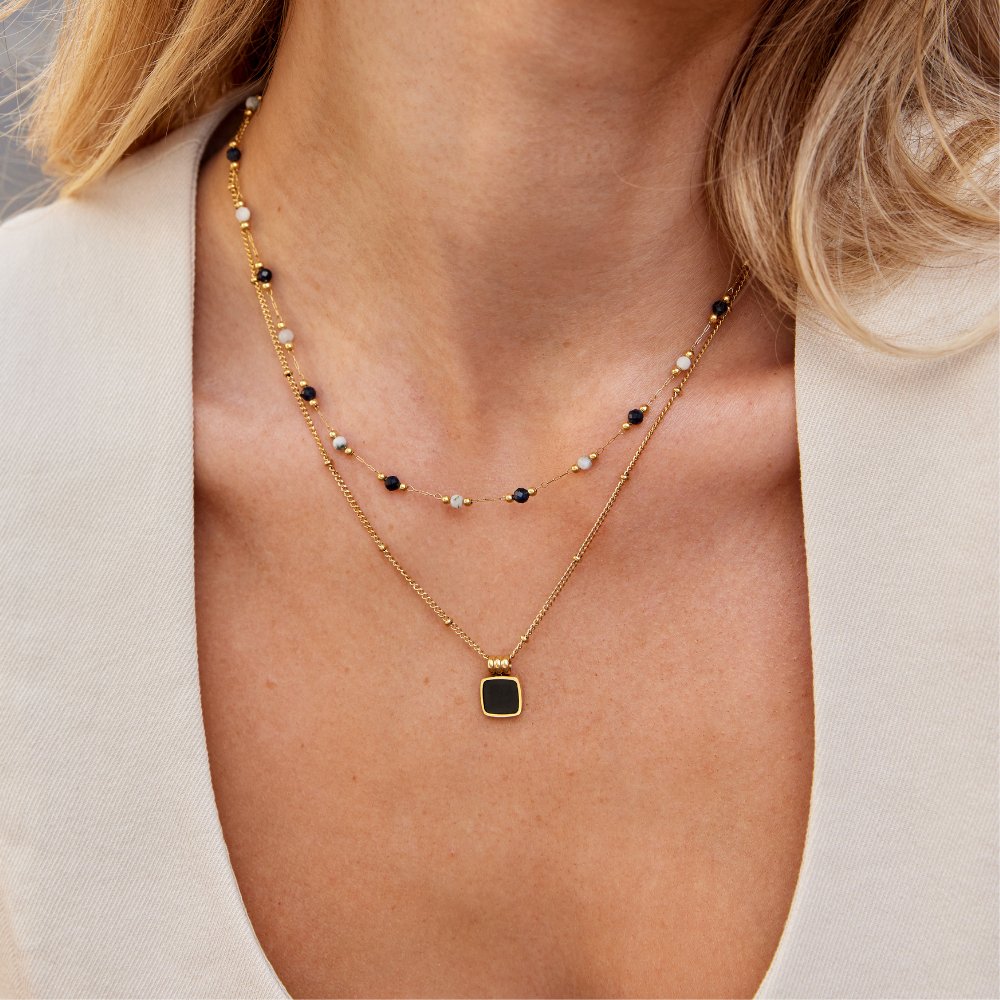 Collier à couches Danoir Paris avec perles et pierres, élégant et délicat, porté en style sophistiqué.