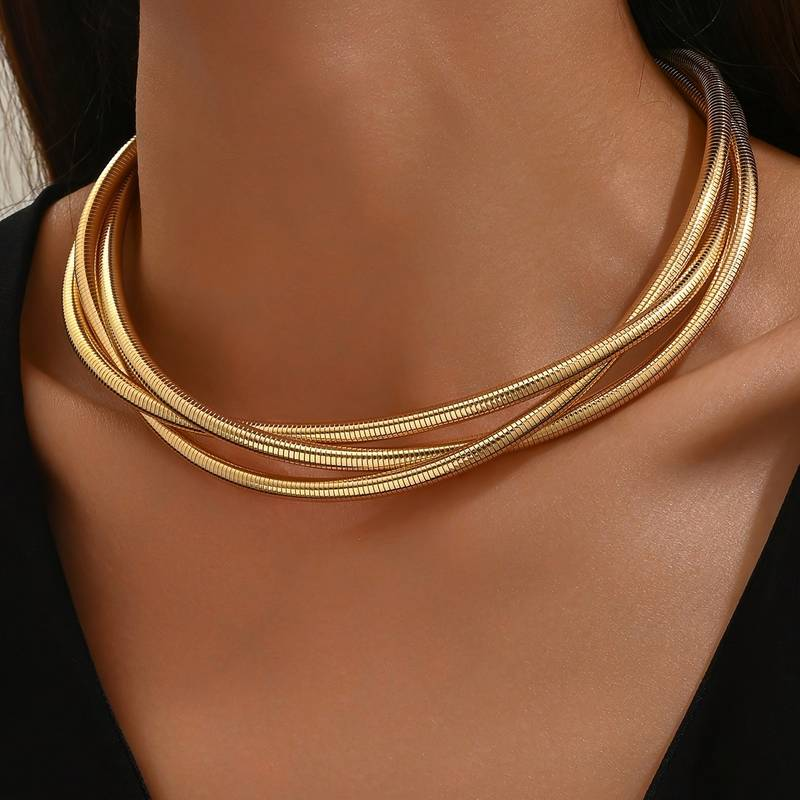 Collier doré vintage à couches Danoir Paris avec détails élégants, porté sur un mannequin en tissu beige.