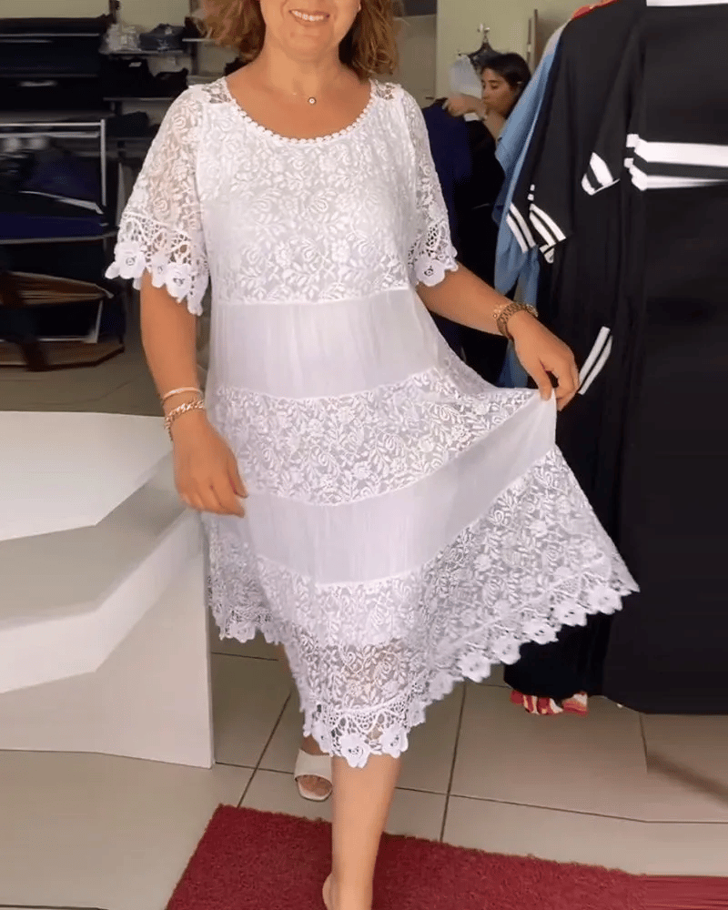 Robe mi-longue blanche en dentelle à plusieurs couches, style tiers, par Danoir Paris, portée avec détails élégants et féminin.