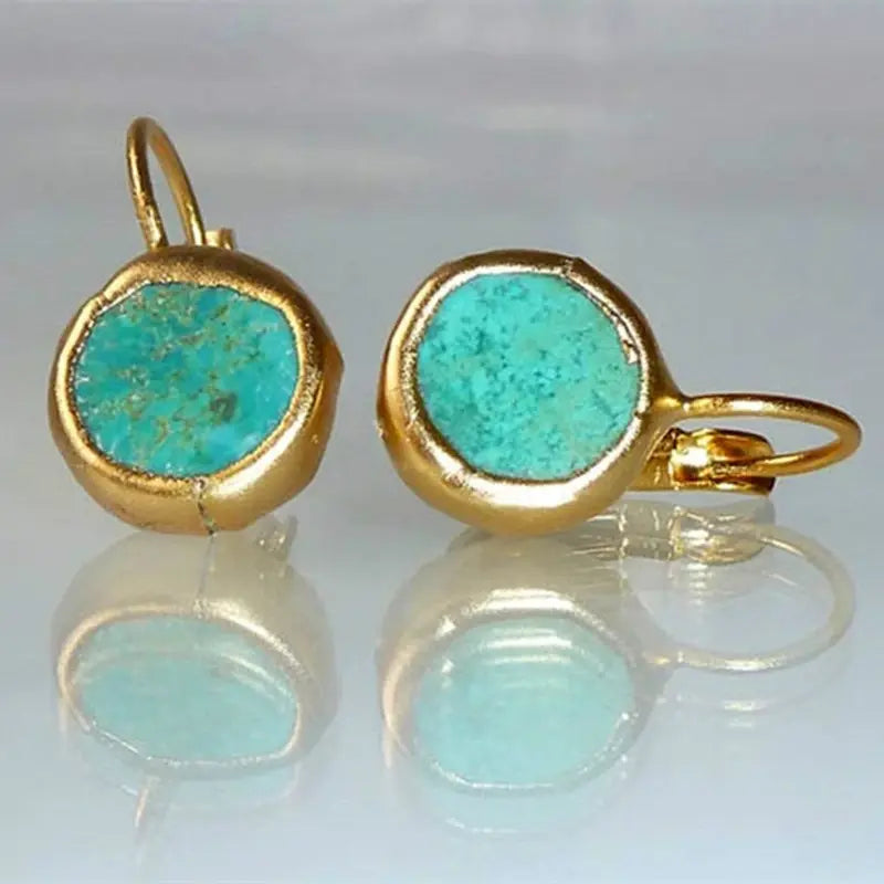 Boucles d'oreilles élégantes en or avec pierre turquoise de la marque Danoir Paris, montrant le détail des bijoux.