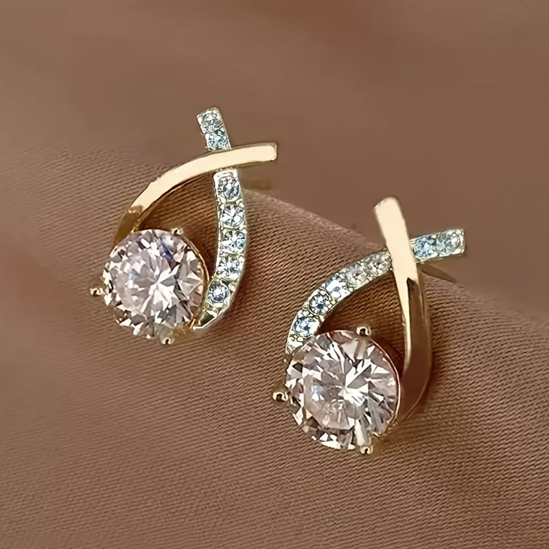 Boucles d'oreilles en puce Danoir Paris avec croix dorée et zirconiums, élégantes et discrètes.