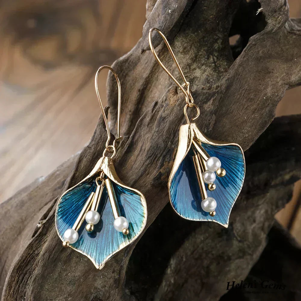 Boucles d'oreilles pendantes Danoir Paris en or avec des perles bleues élégantes.