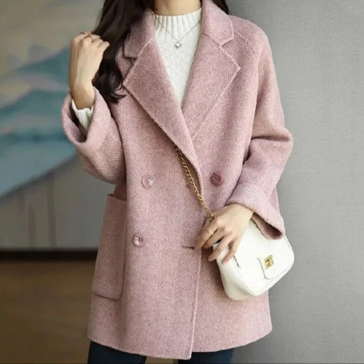 Manteau cachemire élégant Megan de Danoir Paris, coloris rose, porté sur un fond neutre, mettant en valeur le tissu doux et sophistiqué.