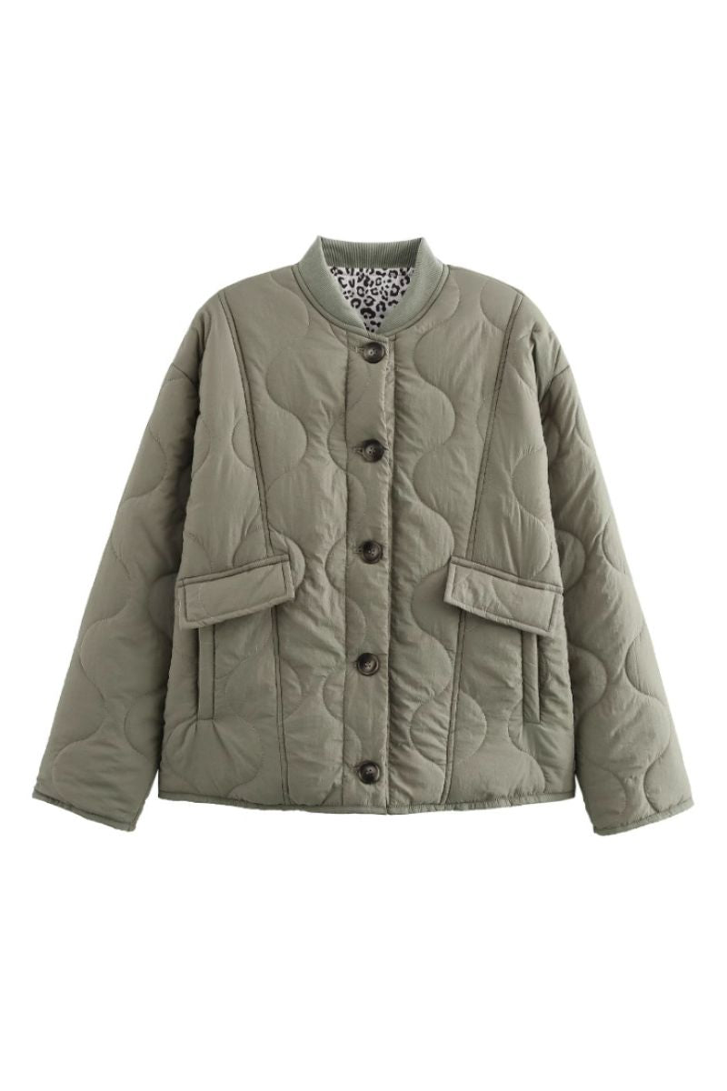 Veste matelassée moderne Noemi™ de Danoir Paris, style élégant avec fermeture éclair et col montant, en tissu noir.
