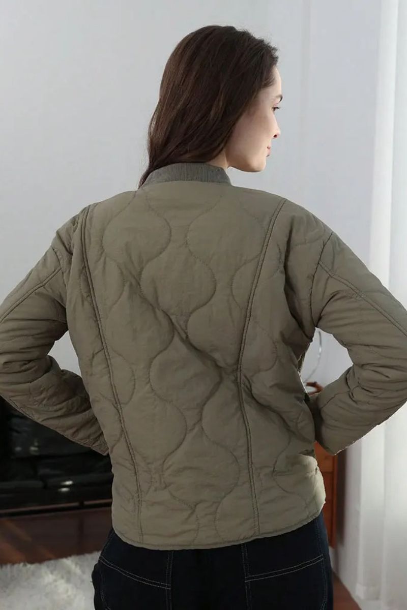 Veste matelassée moderne Noemi™ de Danoir Paris, coupe élégante, tissu noir avec fermeture éclair visible.