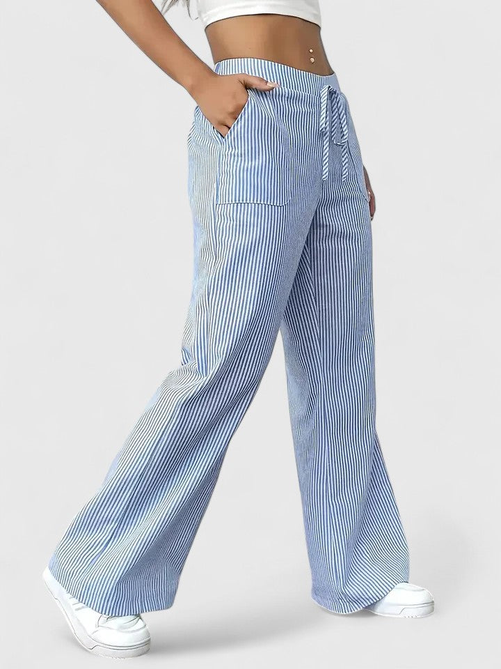 Pantalon large élégant Dominique de Danoir Paris, tissu fluide noir, coupe droite, porté avec une blouse blanche.