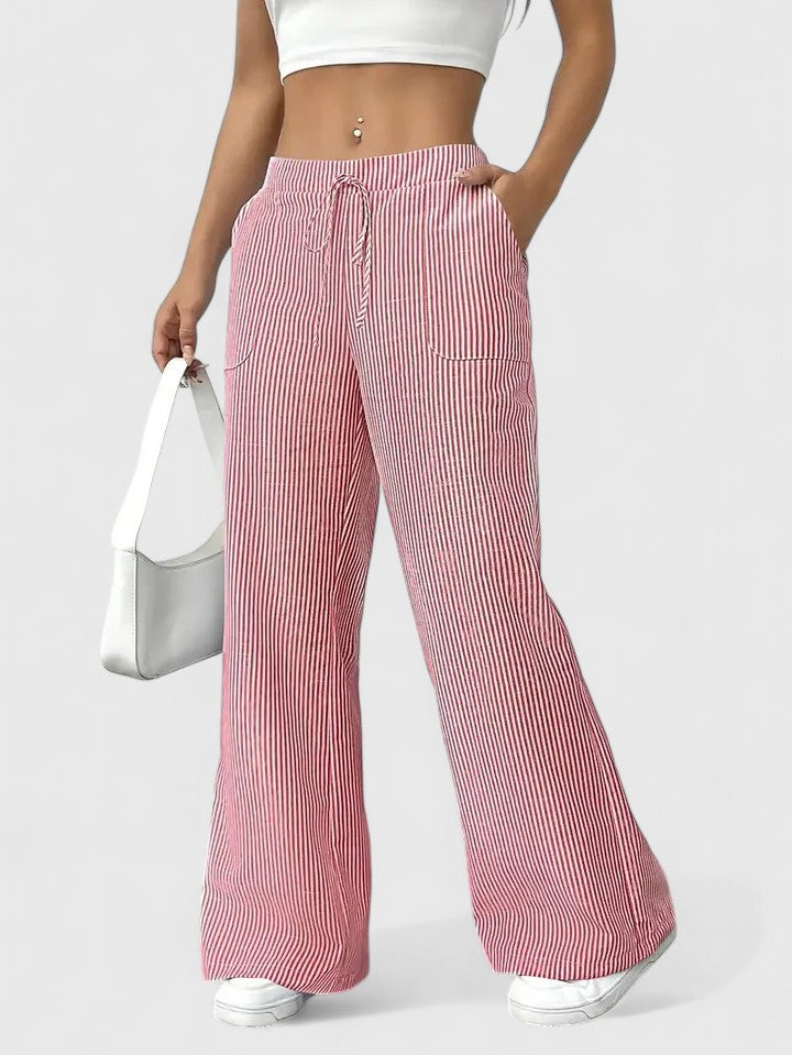 Pantalon large élégant Dominique de Danoir Paris en tissu fluide, couleur neutre, porté avec une blouse blanche.