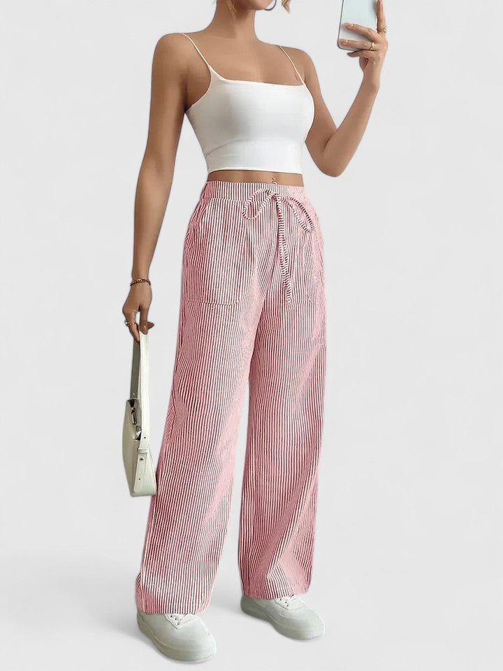Pantalon large élégant Dominique de Danoir Paris en tissu fluide, noir, porté avec une blouse blanche, vue de face.