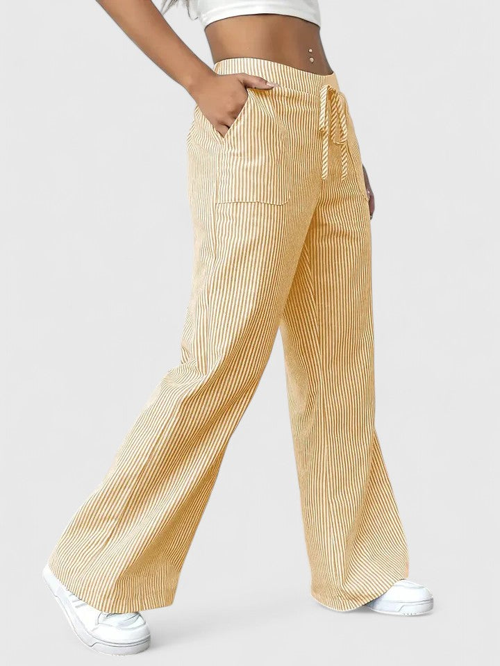 Pantalon large élégant Dominique de Danoir Paris, tissu fluide et coupe sophistiquée, porté avec une chemise blanche.