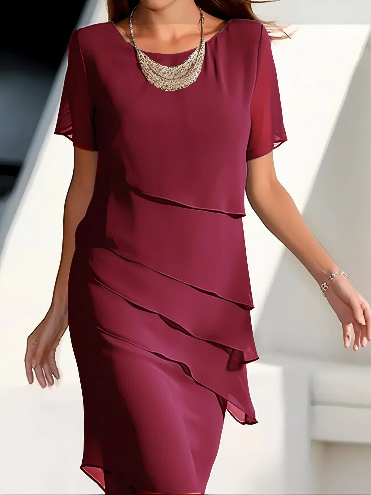 Robe plissée rouge Louise de Danoir Paris, élégante, longue avec détails sophistiqués, portée pour une allure chic et raffinée.