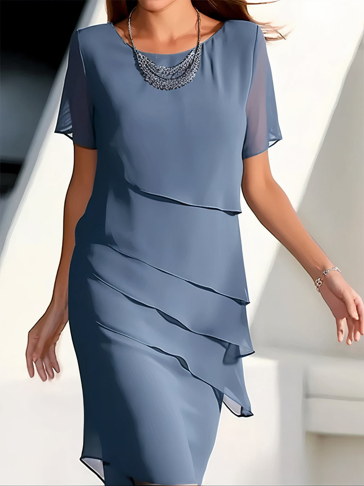 Robe plissée rouge élégante Louise de Danoir Paris portée par une mannequin, détail du tissu fluide et style sophistiqué.