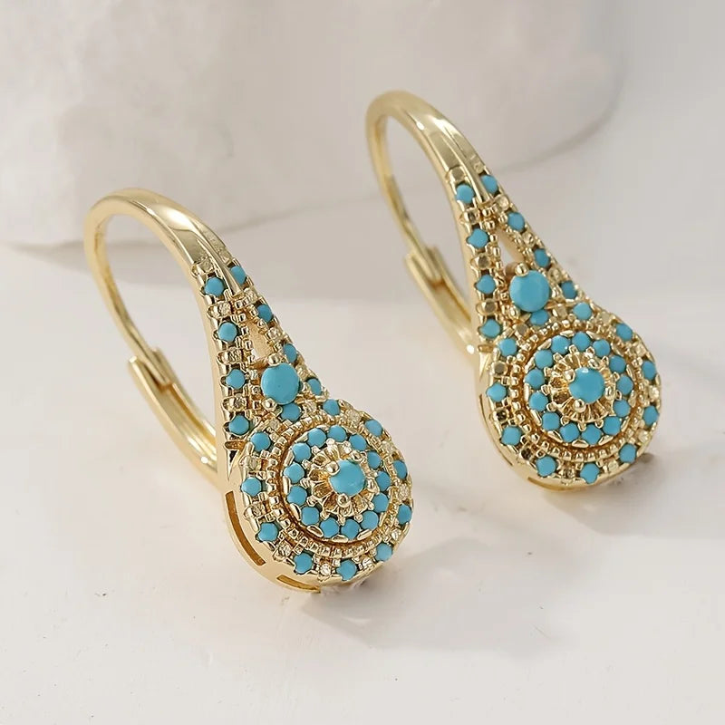 Boucles d'oreilles Danoir Paris ornementées de turquoise et de fleurs dorées, élégantes et raffinées, pour un style sophistiqué.