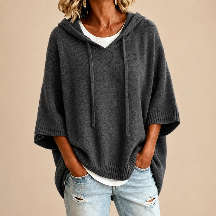 Poncho en tricot bleu marine avec capuche de la marque Danoir Paris, vue en gris.