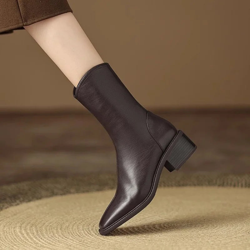 Bottines Danoir Paris Joséphine avec bout carré et talon bloc, en cuir noir, sur une surface en bois.