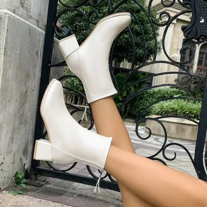 Bottines à talon bloc Danoir Paris Victoire avec zip arrière et finition élégante, portées sur un fond neutre.