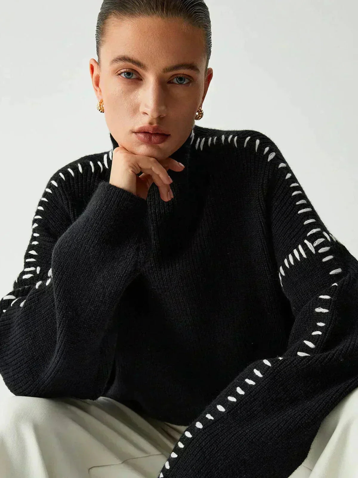 Pull Danoir Paris Nia en laine côtelée à col roulé noir, style automnal, avec détails de surpiqûres whipstitch.