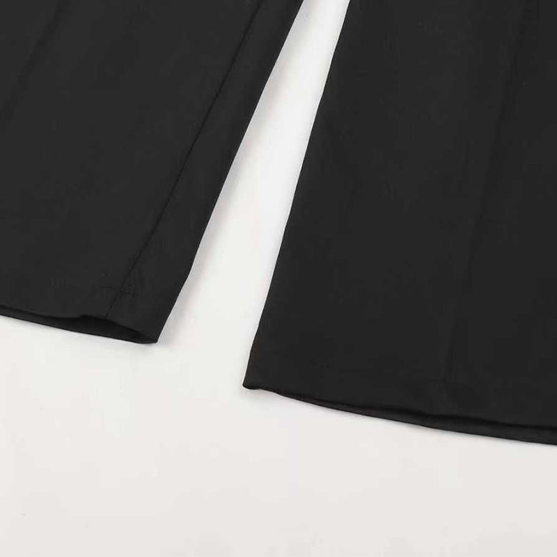 Pantalon de costume taille haute pour femmes Danoir Paris, coupe élégante en tissu noir, porté avec une blouse blanche.