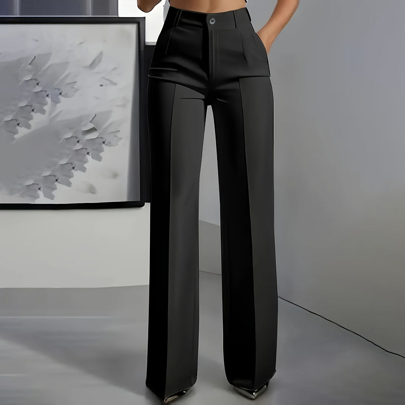 Pantalon de costume taille haute pour femmes Danoir Paris, coupe élégante en tissu noir, porté avec une blouse blanche.